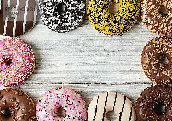 Draufsicht auf verschiedene Donuts auf einem hölzernen Hintergrund