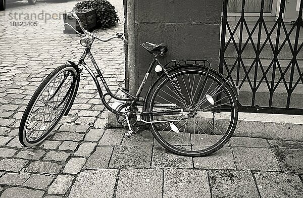 Altes Fahrrad an einer Straßenecke  in schwarzweiß