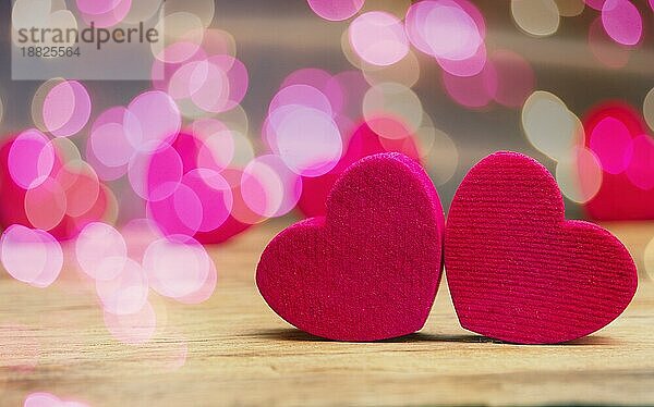Kleine Holzherzen auf einem Holztisch mit schönen rosa Bokeh Effekte und Platz für Text  Valentinstag oder konzeptionelle Liebe Hintergrund