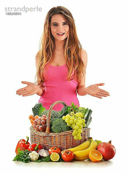 Junge attraktive Frau mit einer Vielzahl von frischem Gemüse und Obst vor weißem Hintergrund