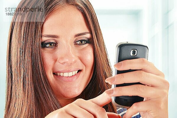 Lächelnde junge Frau mit Smartphone. Selfie