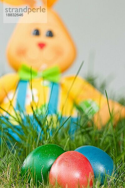 spielzeug osterhase im garten mit bunten ostereiern