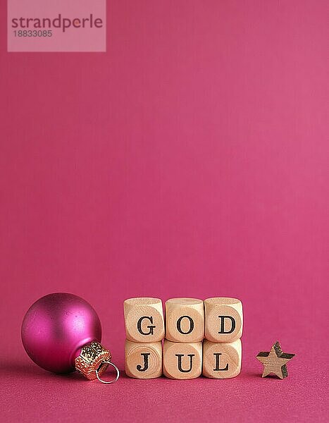 Kleine Holzblöcke mit der Aufschrift God Jul  skandinavische Frohe Weihnachten  lila Hintergrund  minimalistische hölzerne Weihnachtsdekoration