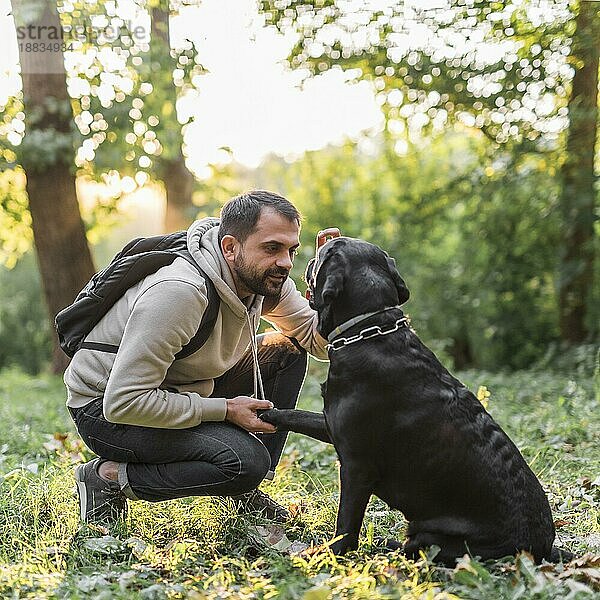 Junger Mann mit seinem Hund im Park