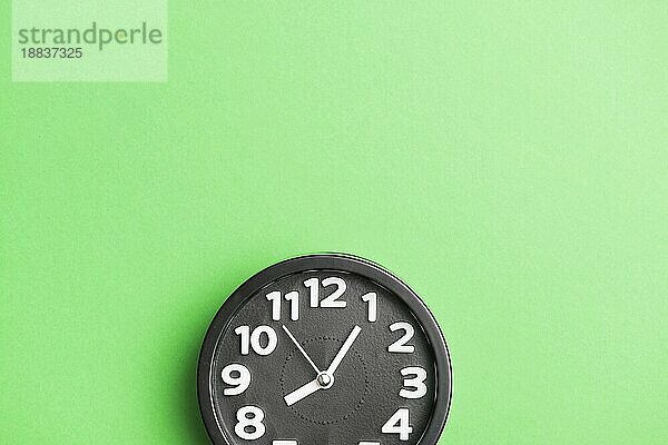 Kreisförmige schwarze Uhr grüner Wandhintergrund. Schönes Foto