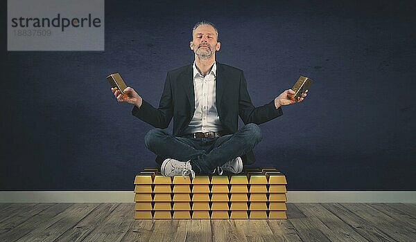 Entspannter und zufriedener Geschäftsmann sitzt auf einem Stapel von Goldbarren  Konzept Einkommen und Wohlstand