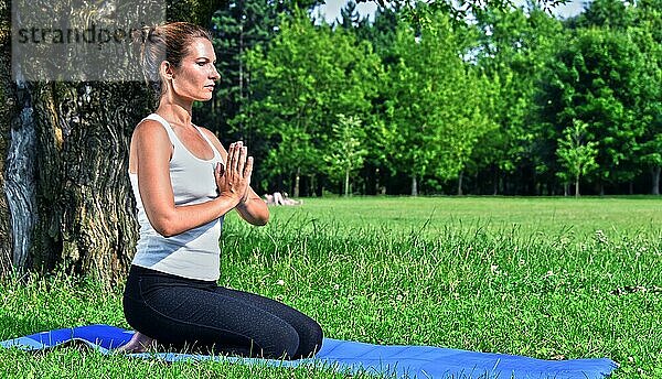 Junge Frau bei der YogaMeditation im Park