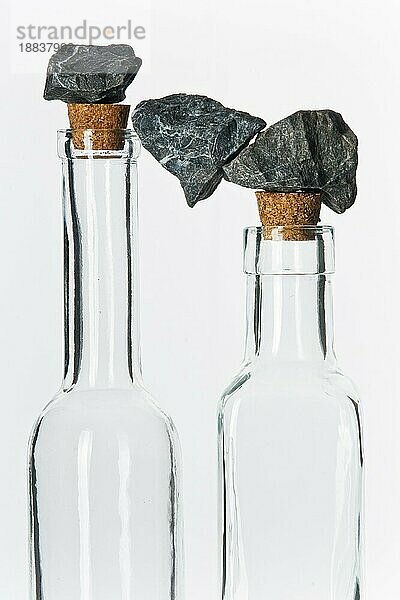 steine in balance auf glasflaschen mit korken