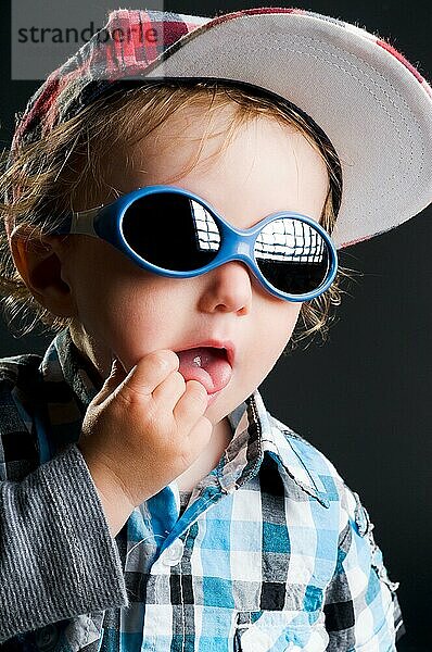 lässiges cooles junges kind mit mütze und sonnenbrille