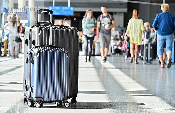 Zwei Plastikreisekoffer in der Flughafenhalle