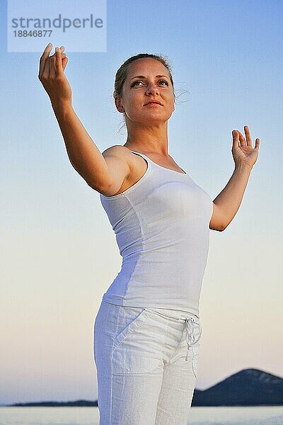 Junge Frau bei der YogaMeditation am Strand