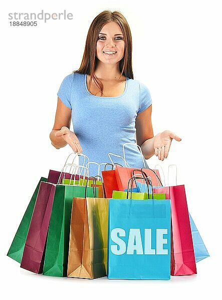 Junge glückliche Frau mit bunten Papier Einkaufstaschen vor weißem Hintergrund