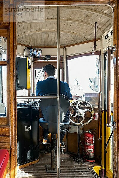 Innenansicht einer historischen Straßenbahn mit Fahrer  in den Straßen von Lissabon