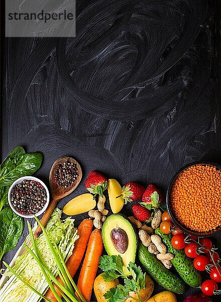 Gemüse  Früchte  Linsen  rohe Zutaten zum Kochen  Löffel auf rustikalen schwarzen Kreidetafel Hintergrund. Gesundes  sauberes Essen Konzept. Vegane oder glutenfreie Ernährung. Platz für Text. Ansicht von oben. Lebensmittel-Rahmen