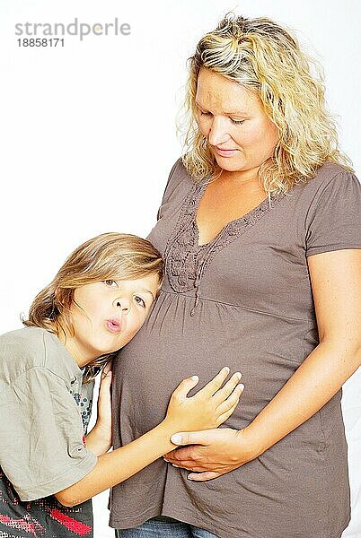 Sohn hört am Bauch von schwangerer Mutter
