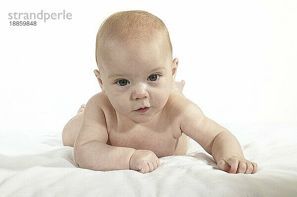 Nude Baby Boy sitzt gegen weißen Hintergrund