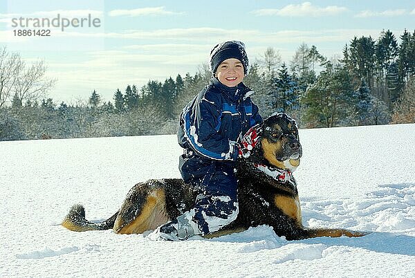 Junge mit Mischlingshund  Skianzug  Mütze
