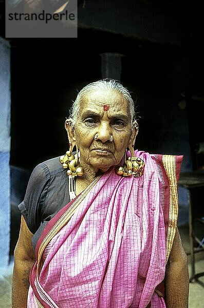 Eine alte Frau trägt einen massiven Thandatti-Ohrring  um ihre Ohrläppchen zu verlängern  Courtalam Kutralam Kuttalam  Tamil Nadu  Südindien  Indien  Asien