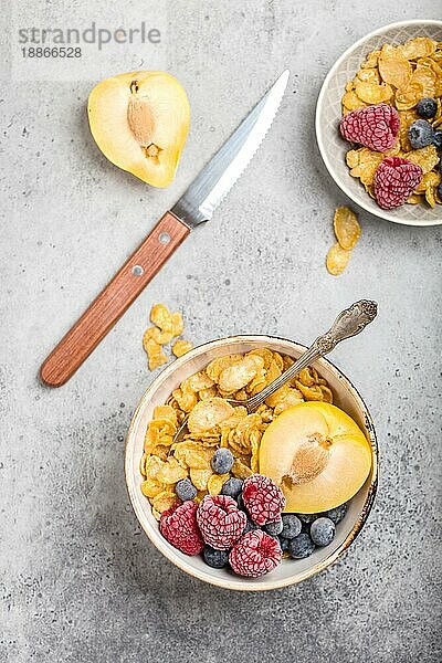 Gesundes Frühstück Schüssel  Müsli  frisches Obst  Beeren auf dem Tisch. Saubere Ernährung  Diät-Konzept. Ansicht von oben. Gesunde Schüssel mit Müsli  Himbeeren  Blaubeeren  Pflaume. Müsli. Vegetarisch. Selektiver Fokus