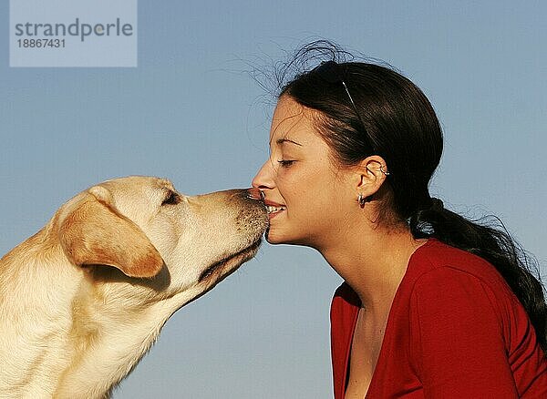 Frau küsst Labrador-Retriever