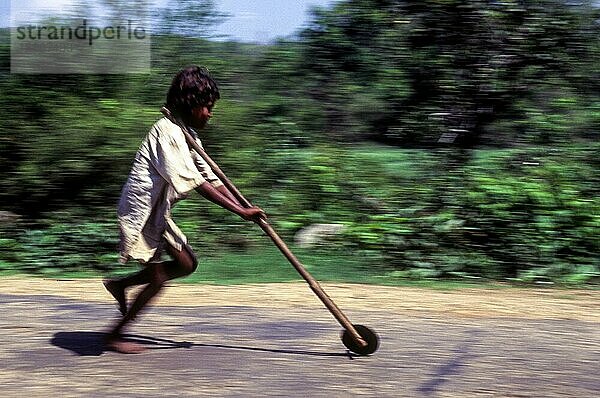 Schwenken  Stammesjunge spielt improvisierten Flaschenzug in Balle  Kabini  Karnataka  Südindien  Indien  Asien