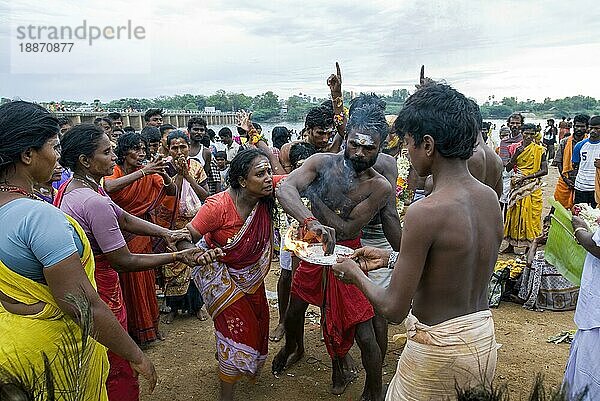 Ein Mann  der versucht  eine Frau zu kontrollieren  die von der Macht Gottes beeinflusst ist und heilige Asche aufträgt  Vaikasi Visakam Festival in Tiruchendur  Tamil Nadu  Südindien  Indien  Asien