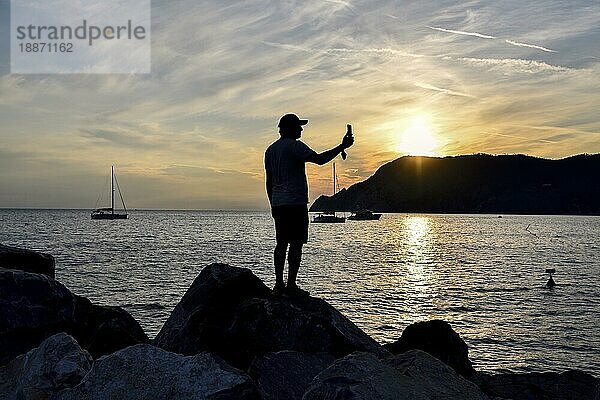 Mann fotografiert  blaue Stunde mit dem Handy im Hafen von Vernazza  Cinque Terre  Provinz La Spezia  Ligurien  Italien  Europa