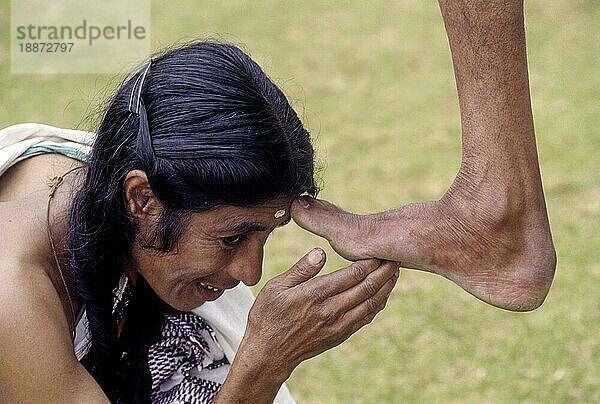 Toda  die zur Begrüßung ihren rechten Fuß heben und ihn für ihren Segen in den Kopf der Frau stecken  Ooty Udhagamandalam  Nilgiris  Tamil Nadu  Südindien  Indien  Asien