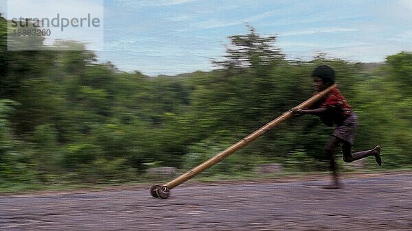 Stammesjunge spielt improvisierten Flaschenzug in Balle  Kabini  Karnataka  Südindien  Indien  Asien