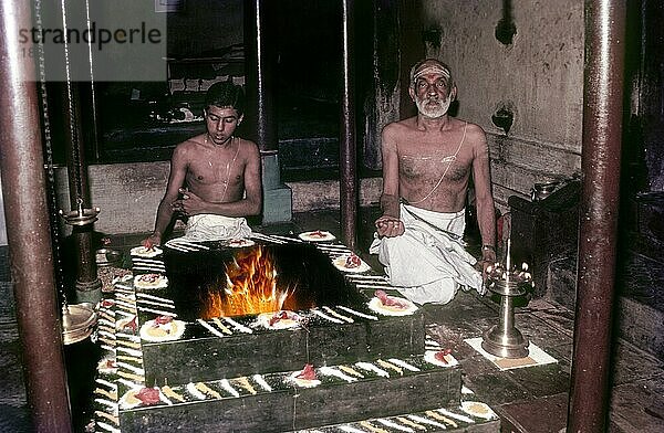 Großvater und Enkel bei der Durchführung der Pooja Agni Havana Homa Kunda pooja Indian Traditional Pooja  Kerala  Südindien  Indien  Asien