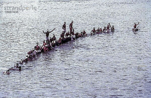 Teilnehmer auf einem gesunkenen Boot beim Aranmula-Bootsrennen während des Onam-Festes in der Nähe von Haripad  Kerala  Indien  Asien