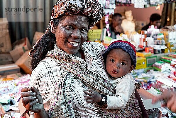 Toba Batak Frau mit Baby in traditioneller Kleidung auf dem Wochenmarkt von Pangururan  dem Hauptort der Toba auf der Insel Samosir auf Sumatra