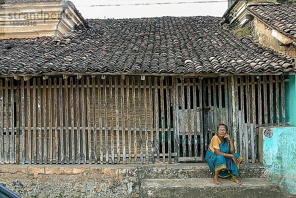 Eine alte Frau sitzt auf den Stufen eines gekachelten alten Hauses in Mayiladuthurai  Tamil Nadu  Südindien  Indien  Asien