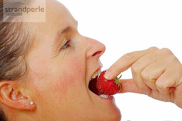 Frau ißt Erdbeere  seitlich