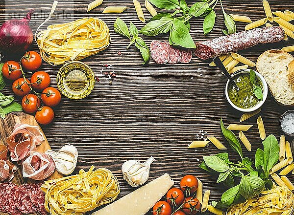 Draufsicht auf italienische traditionelle Lebensmittel  Vorspeisen und Snacks wie Salami  Prosciutto  Käse  Pesto  Ciabatta  Olivenöl  Pasta auf rustikalem Holzhintergrund mit Platz für Text in der Mitte  Retro-Stil