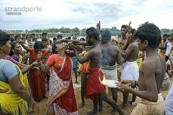 Ein Mann  der versucht  eine Frau zu kontrollieren  die von der Macht Gottes beeinflusst ist und heilige Asche aufträgt  Vaikasi Visakam Festival in Tiruchendur  Tamil Nadu  Südindien  Indien  Asien