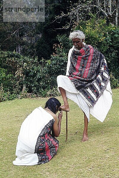 Toda  die zur Begrüßung ihren rechten Fuß heben und ihn für ihren Segen in den Kopf der Frau stecken  Ooty Udhagamandalam  Nilgiris  Tamil Nadu  Südindien  Indien  Asien