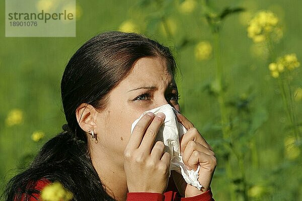 Frau mit Heuschnupfen schnäuzt sich die Nase  niesen  niest  Schnupfen  Allergie