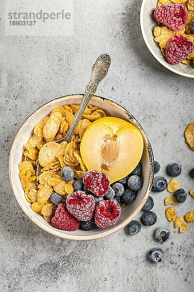 Gesundes Frühstück Schüssel  Müsli  frisches Obst  Beeren auf dem Tisch. Saubere Ernährung  Diät-Konzept. Ansicht von oben. Gesunde Schüssel mit Müsli  Himbeeren  Blaubeeren  Pflaume. Müsli. Vegetarisch. Selektiver Fokus