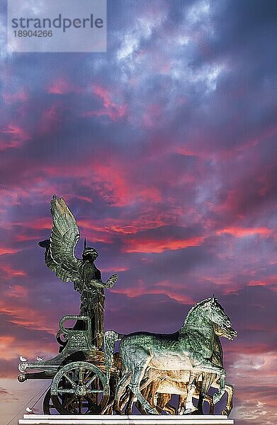 Die Quadriga der Einheit auf der Spitze einer der beiden Propyläen am Nationaldenkmal Viktor Emanuel II. (Vittoriano) bei Sonnenuntergang. Rom Italien