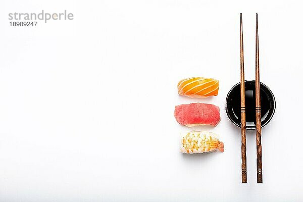 Set von verschiedenen Sushi Nigiri  Sojasauce und Essstäbchen auf weißem Hintergrund mit Kopierraum  Ansicht von oben. Traditionelles japanisches Sushi-Konzept  Nahaufnahme