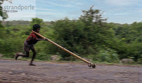 Kameraschwenk  Stammesjunge spielt improvisierten Flaschenzug in Balle  Kabini  Karnataka  Südindien  Indien  Asien