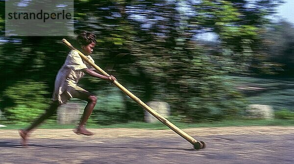 Kameraschwenk  Stammesjunge spielt improvisierten Flaschenzug in Balle  Kabini  Karnataka  Südindien  Indien  Asien