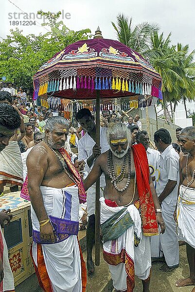 Tempelpriester unter dem Regenschirm während des Vinayak Chaturthi Ganesh Chaturthi Festes im Sri Karpaga Vinayakar Tempel in Pillaiyarpatti bei Karaikudi  Tamil Nadu  Südindien  Indien  Asien