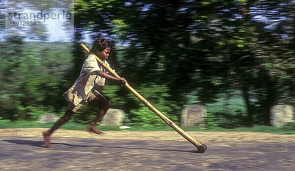 Kameraschwenk  Stammesjunge spielt improvisierten Flaschenzug in Balle  Kabini  Karnataka  Südindien  Indien  Asien