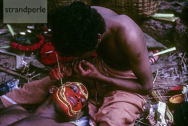 Theyyam  Kompliziertes Make-up erfordert Hilfe  Kerala  Südindien  Indien  Asien