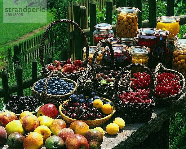 Verschiedene Obstsorten in Körben und eingemachtes Obst in Gläsern