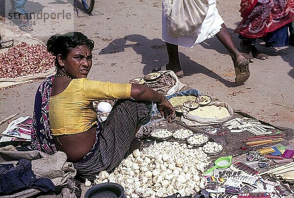 Eine Stammesangehörige verkauft Knoblauch (Allium sativum)  Wochenmarkt in Pollachi  Tamil Nadu  Südindien  Indien  Asien