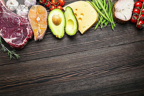 Ketogenic wenig Kohlenhydrate Zutaten für gesunde Gewichtsabnahme Diät  Draufsicht  Kopie Raum. Keto-Lebensmittel auf hölzernem Hintergrund: Fleisch  Fisch  Avocado  Käse  Gemüse  Nüsse Saubere Ernährung  gesunde Fette