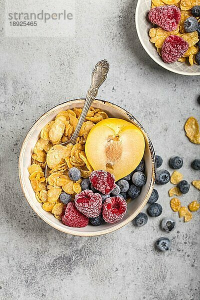 Gesundes Frühstück Schüssel  Müsli  frisches Obst  Beeren auf dem Tisch. Saubere Ernährung  Diät-Konzept. Ansicht von oben. Gesunde Schüssel mit Müsli  Himbeeren  Blaubeeren  Pflaume. Müsli. Vegetarisch. Selektiver Fokus